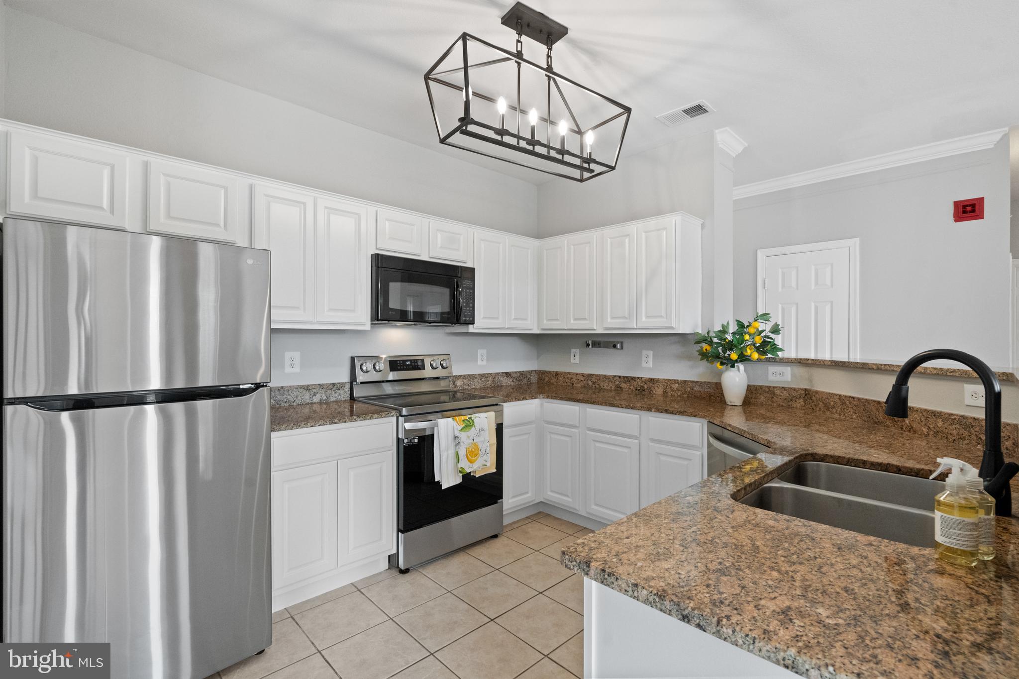 a kitchen with stainless steel appliances granite countertop a refrigerator a sink a stove a microwave and island