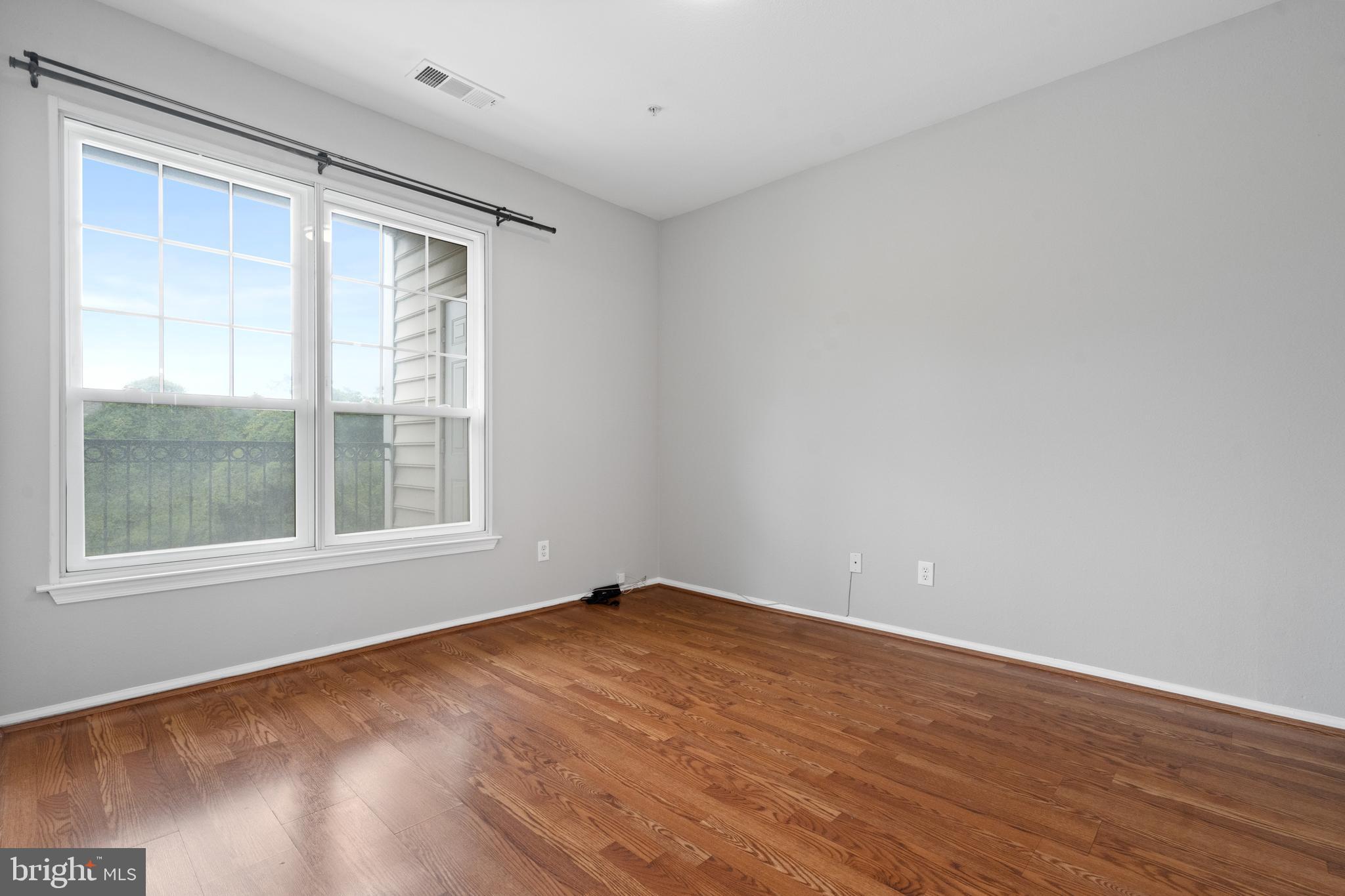 1550 Spring Gate Dr., Unit 8209 McLean, VA 22102 - Photo 13 of 40 an empty room with wooden floor and windows