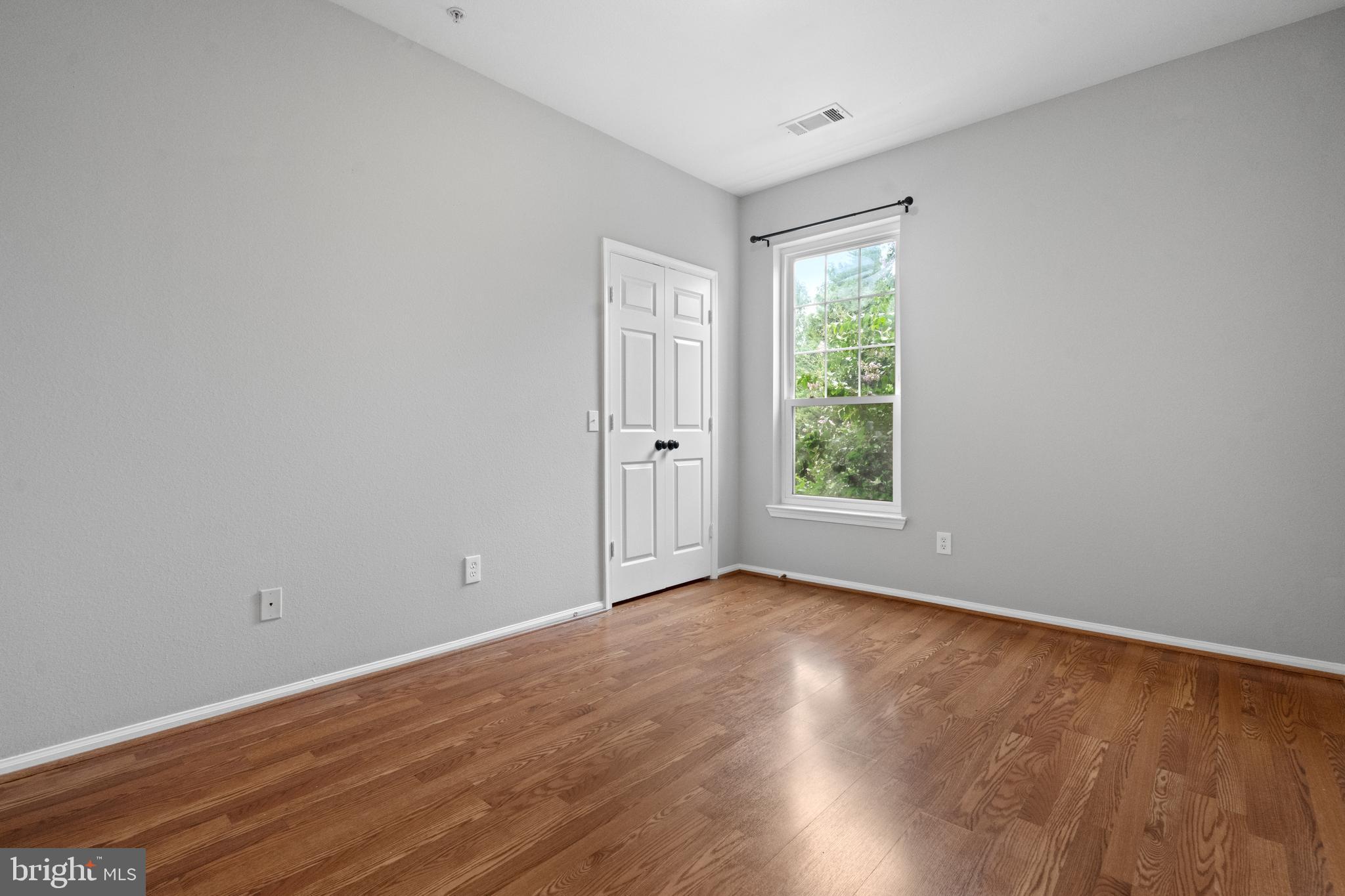 1550 Spring Gate Dr., Unit 8209 McLean, VA 22102 - Photo 18 of 40 a view of an empty room with wooden floor and a window