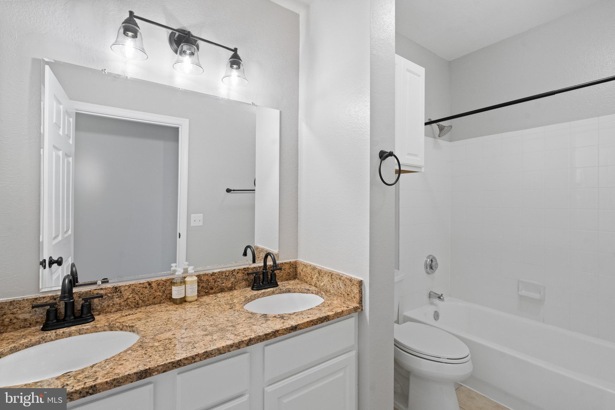 1550 Spring Gate Dr., Unit 8209 McLean, VA 22102 - Photo 21 of 40 a bathroom with a granite countertop sink a toilet and shower