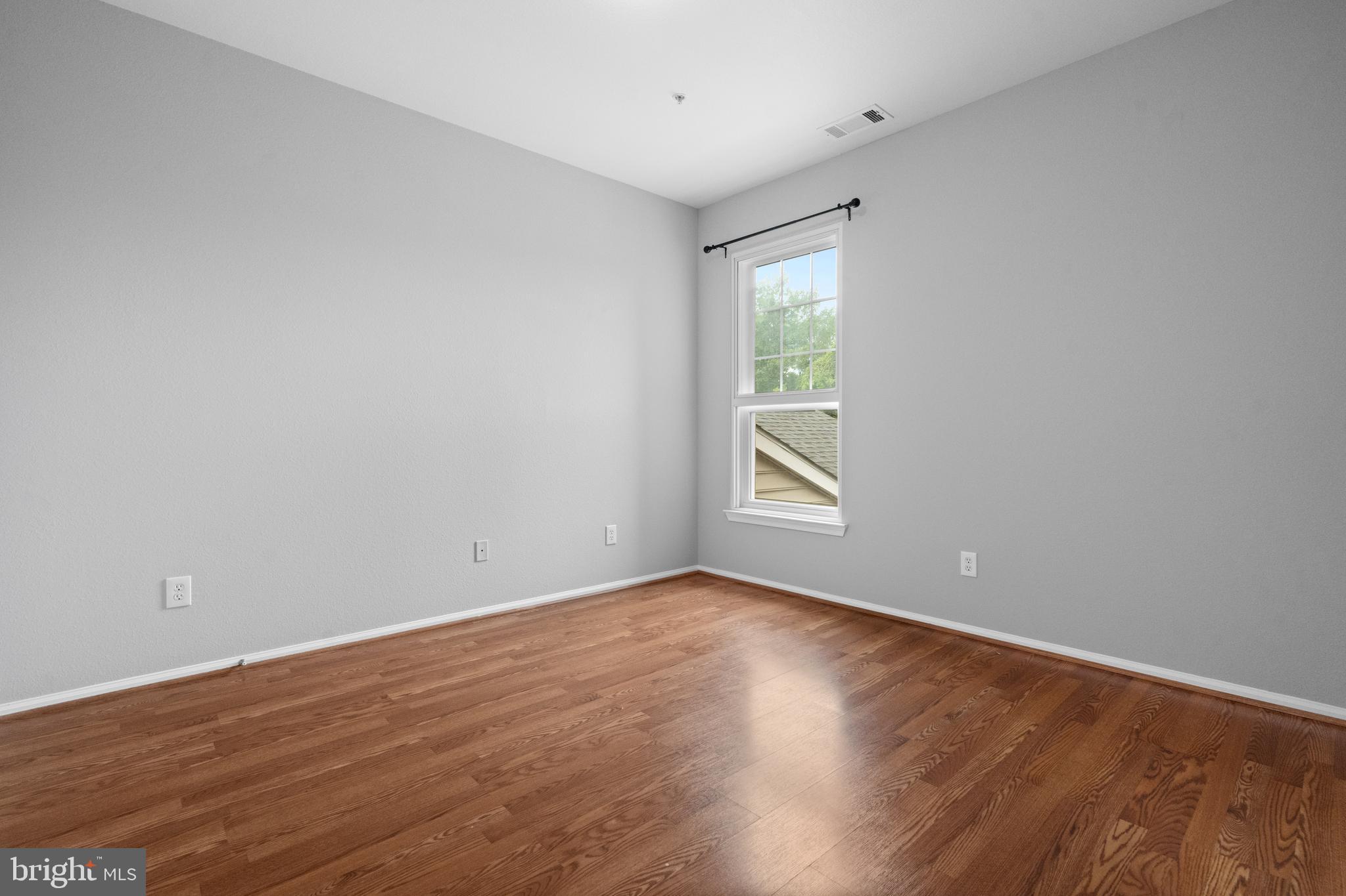1550 Spring Gate Dr., Unit 8209 McLean, VA 22102 - Photo 22 of 40 a view of an empty room with wooden floor and a window