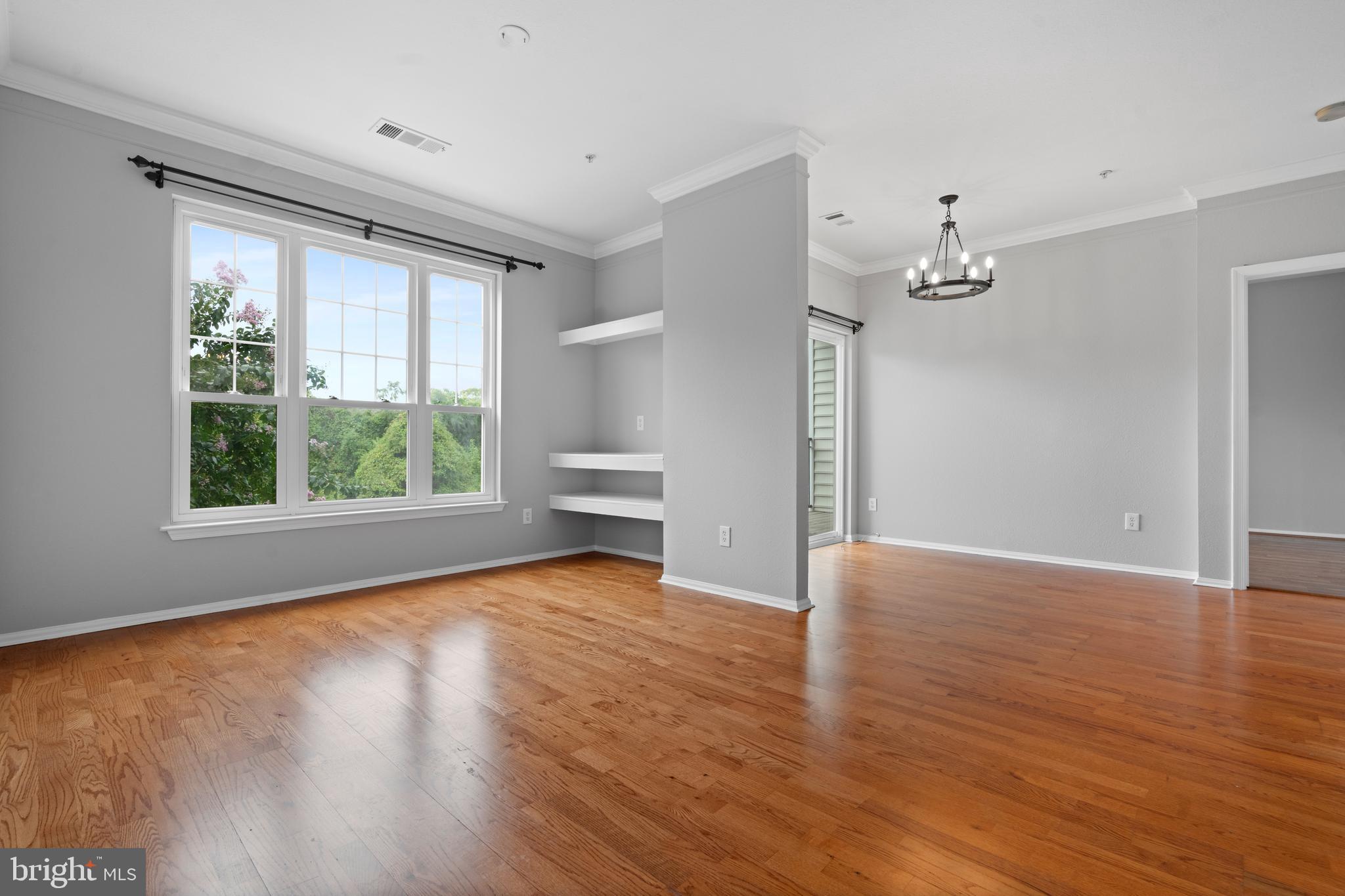1550 Spring Gate Dr., Unit 8209 McLean, VA 22102 - Photo 4 of 40 a view of an empty room with wooden floor and a window