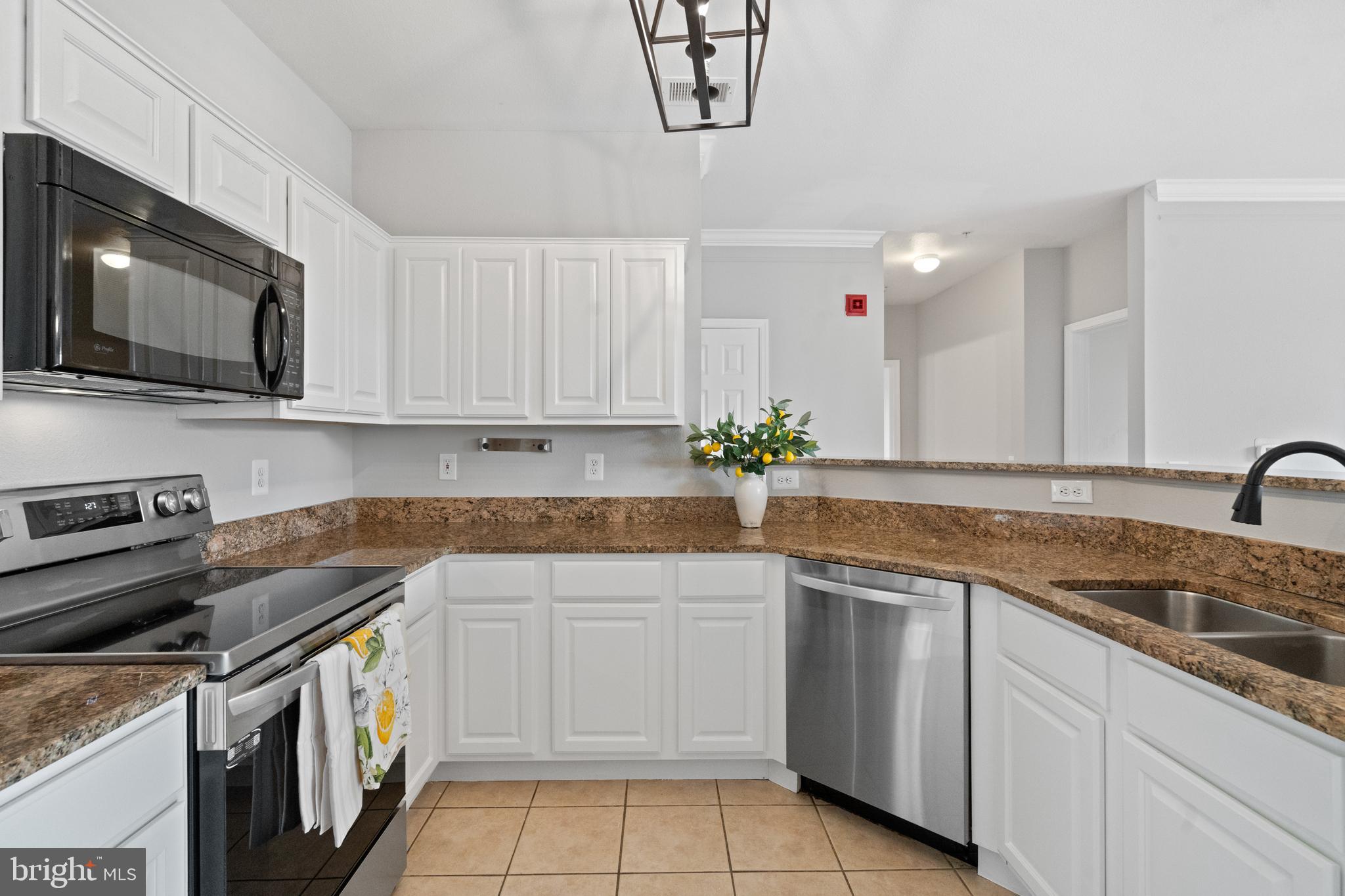 1550 Spring Gate Dr., Unit 8209 McLean, VA 22102 - Photo 9 of 40 a kitchen with granite countertop white cabinets and stainless steel appliances