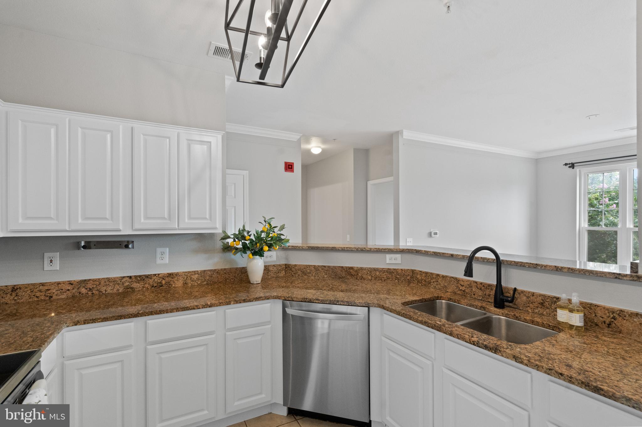 1550 Spring Gate Dr., Unit 8209 McLean, VA 22102 - Photo 10 of 40 a kitchen with granite countertop a sink and white cabinets