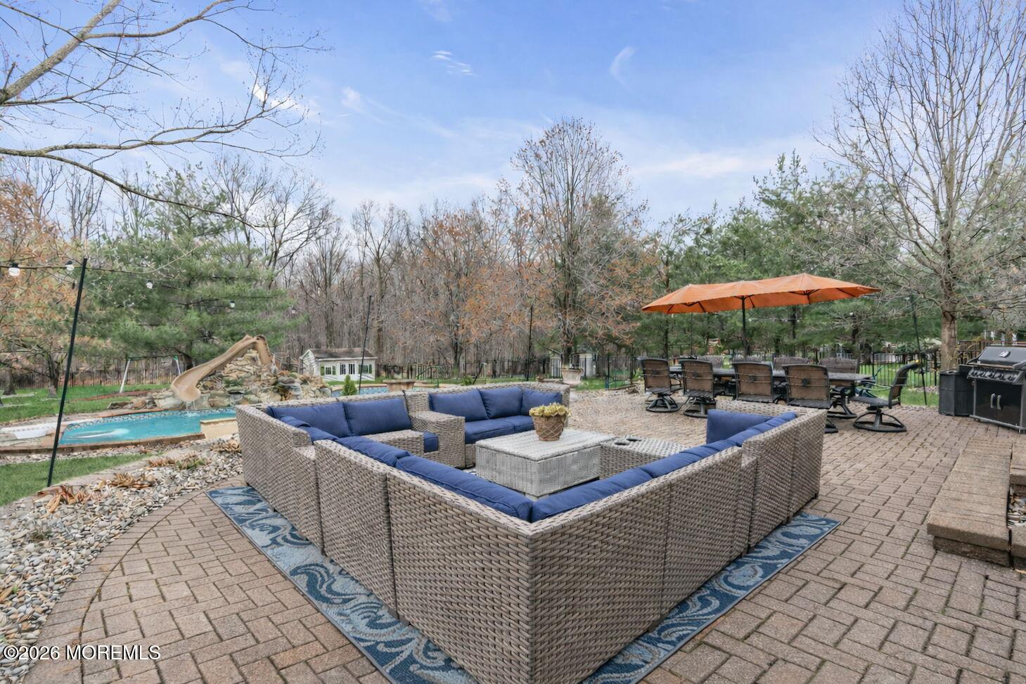 41 Lafayette Mills Road Manalapan, NJ 07726 - Photo 66 of 75 a view of a patio with couches and table and chairs under an umbrella