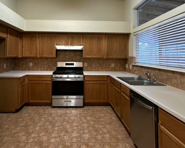 132 Stephen Lane Georgetown, TX 78626 - Photo 4 of 13 Kitchen featuring stainless steel appliances, light countertops, tile floors and wood finish cabinets