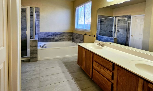 132 Stephen Lane Georgetown, TX 78626 - Photo 6 of 13 Primary bathroom featuring a tub, a stall shower, double vanity, water closet and large walk in closet