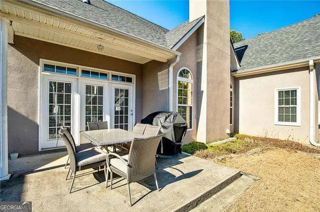 a view of a patio with table and chairs with wooden floor and fence