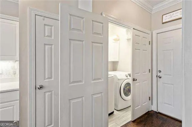 a large kitchen with stainless steel appliances a stove a sink dishwasher a refrigerator white cabinets and wooden floor