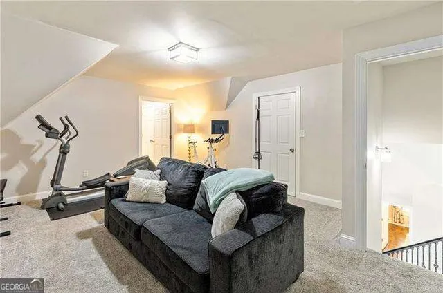 a gym room with furniture and a flat screen tv