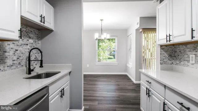 a kitchen with kitchen island a sink wooden floor and a window