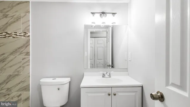 a bathroom with a sink a toilet and mirror