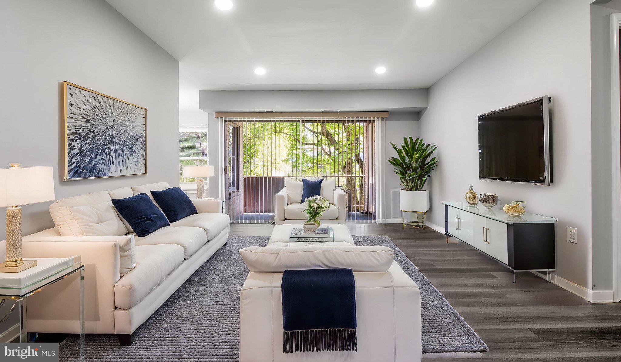 3851 St Barnabas Road, Unit 103 Suitland, MD 20746 - Photo 39 of 43 a living room with furniture and a flat screen tv