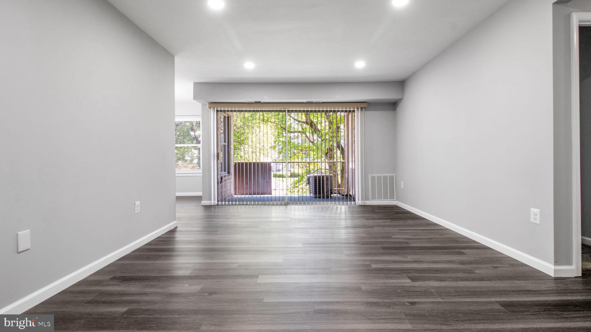 3851 St Barnabas Road, Unit 103 Suitland, MD 20746 - Photo 4 of 43 a view of an empty room with wooden floor and a window