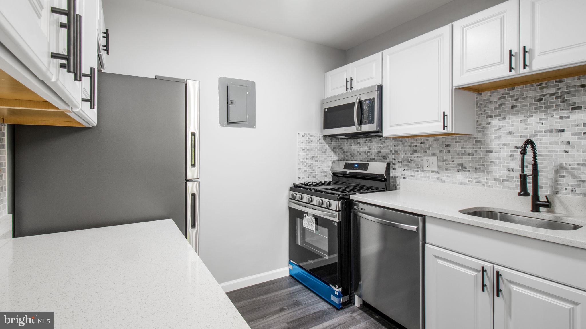 3851 St Barnabas Road, Unit 103 Suitland, MD 20746 - Photo 5 of 43 a kitchen with stainless steel appliances a stove microwave and sink