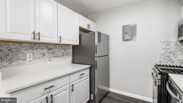 a kitchen with a refrigerator and a stove top oven