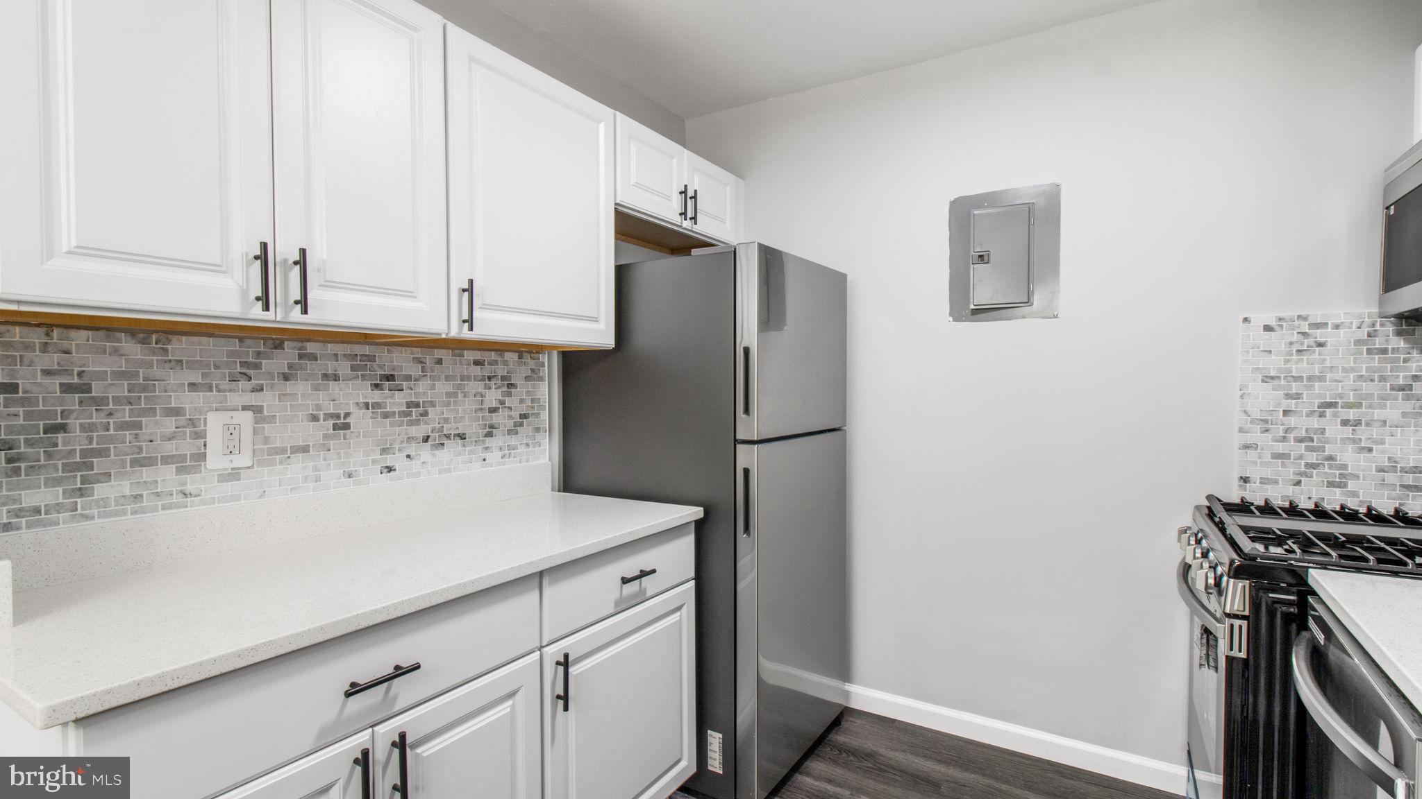 3851 St Barnabas Road, Unit 103 Suitland, MD 20746 - Photo 6 of 43 a kitchen with a refrigerator and a stove top oven