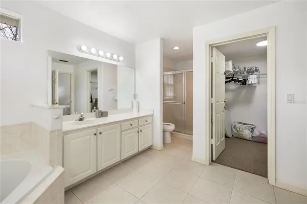 a spacious bathroom with a double vanity sink toilet mirror and bathtub