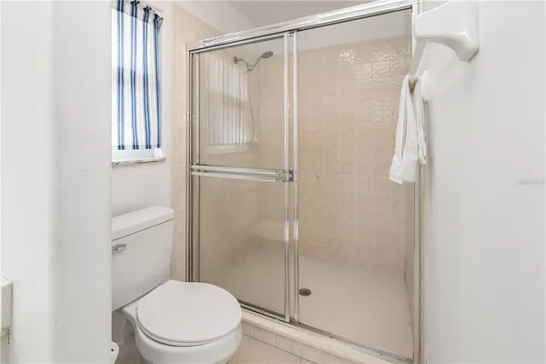 a bathroom with a shower a toilet and a window