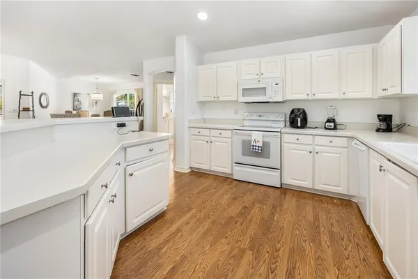 a kitchen with white cabinets appliances and a sink