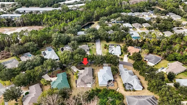 an aerial view of residential houses with outdoor space and trees