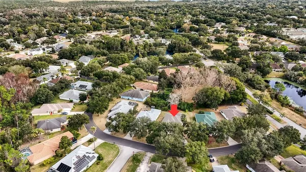 an aerial view of residential houses with outdoor space and trees