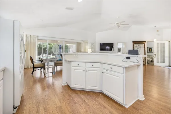 a kitchen with cabinets and wooden floor