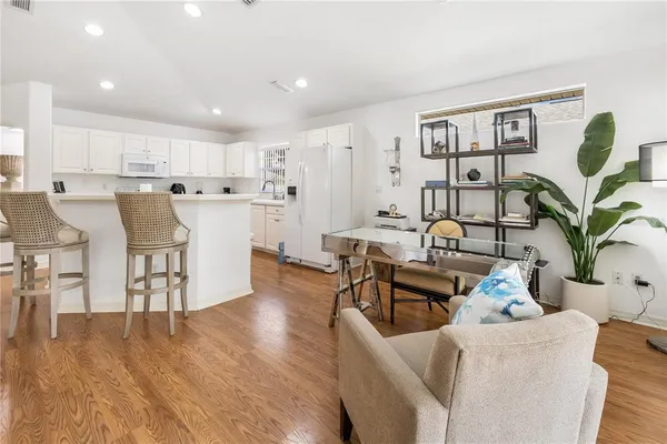 a living room with furniture wooden floor and kitchen view