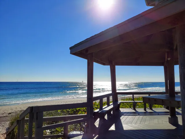 a roof deck with table and chairs a barbeque with wooden fence