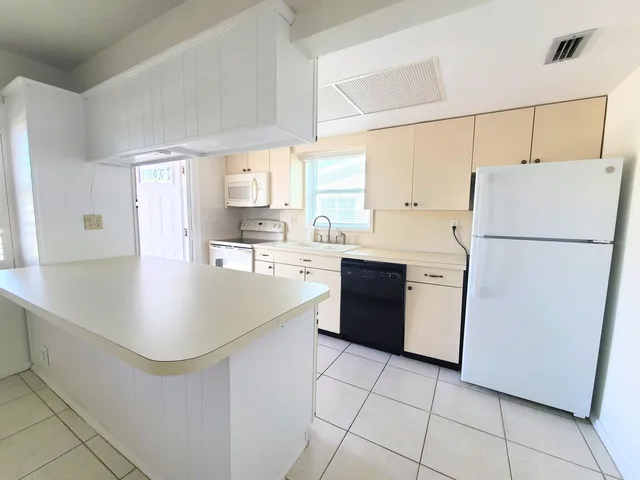 a kitchen with a refrigerator a sink and a stove top oven