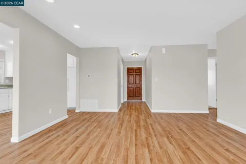 a view of empty room with wooden floor