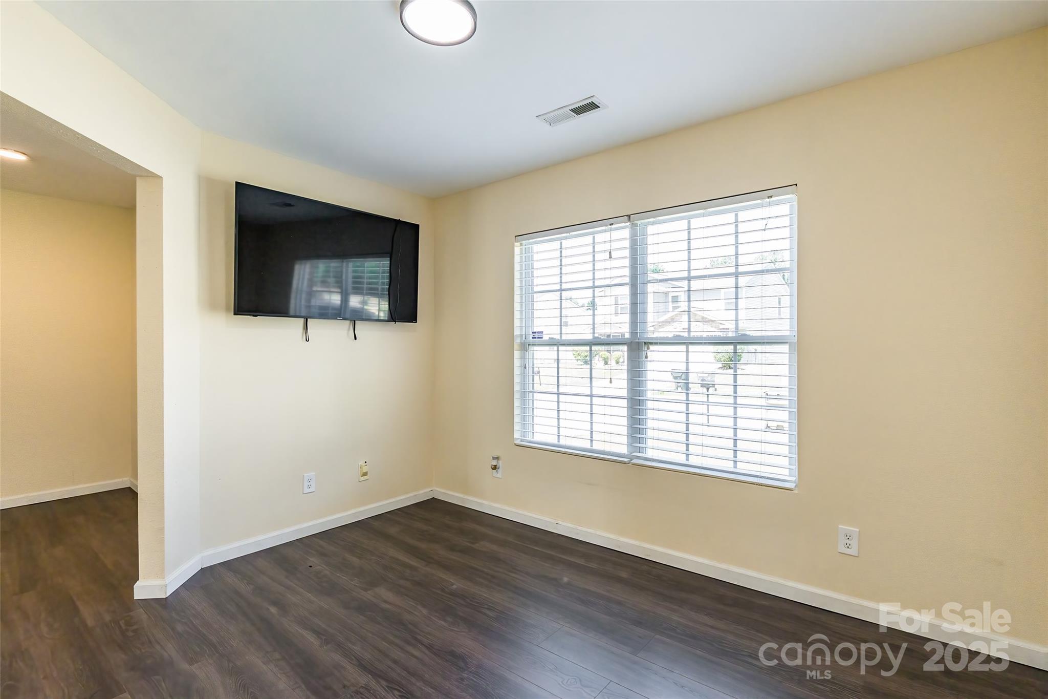 2357 Riding Trail Road Gastonia, NC 28054 - Photo 5 of 32 a view of a livingroom with wooden floor and a flat screen tv