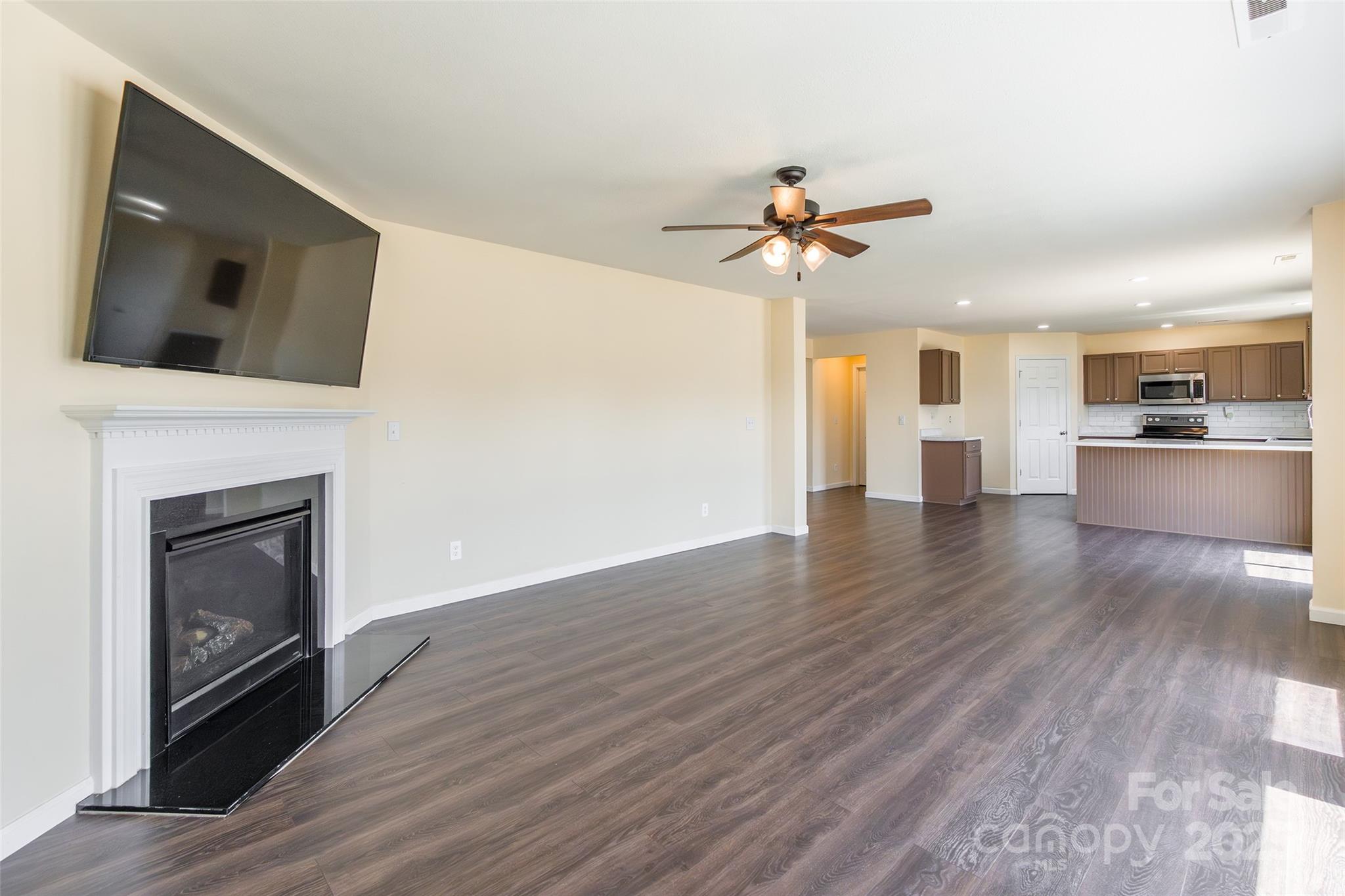 2357 Riding Trail Road Gastonia, NC 28054 - Photo 9 of 32 a view of a kitchen with a ceiling fan fireplace and wooden floor