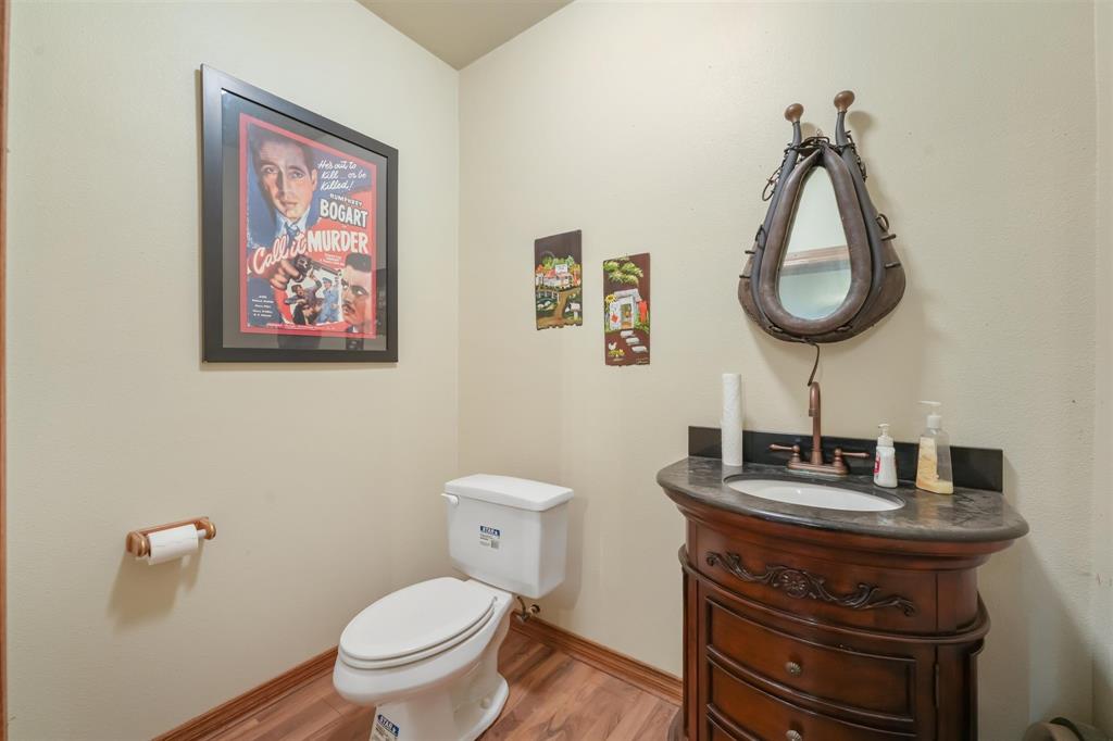 9711 Jim Christal Road Krum, TX 76249 - Photo 29 of 38 a bathroom with a toilet a sink and mirror