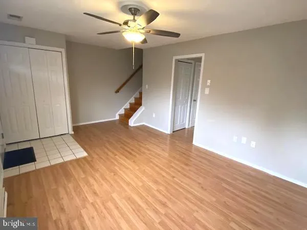 a view of a livingroom with wooden floor and a ceiling fan