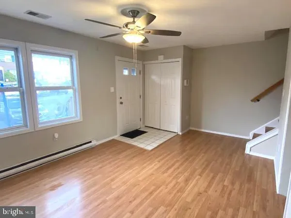 a view of an empty room and window and wooden floor