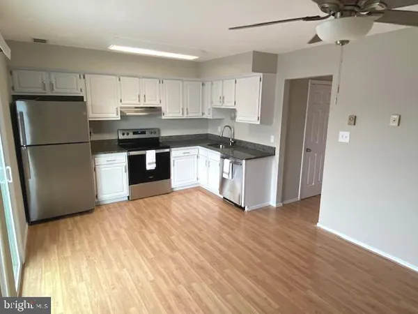 a kitchen with granite countertop a refrigerator and a stove top oven