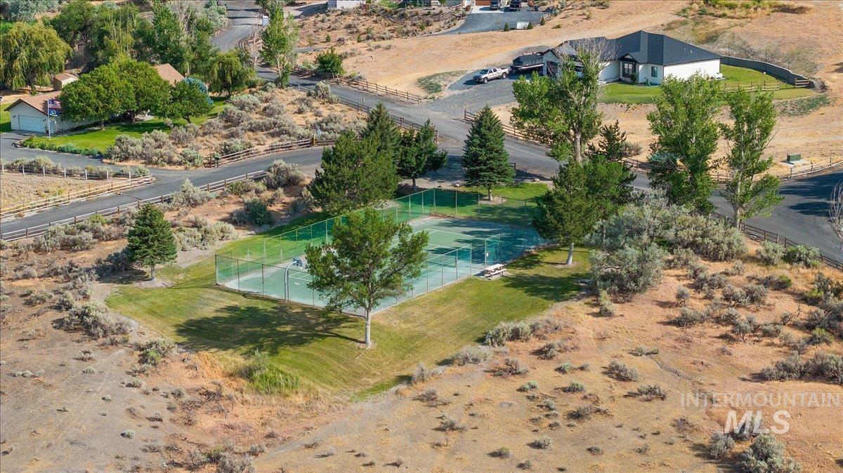 4485 Silver Creek Road Buhl, ID 83316 - Photo 50 of 50 Hard tennis court with surrounding fencing, mature trees, and grass border