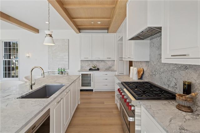 a kitchen with granite countertop a sink stove and cabinets
