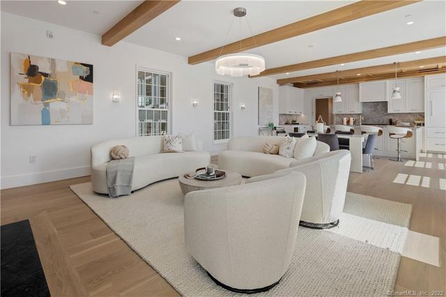a living room with furniture a rug and white doors