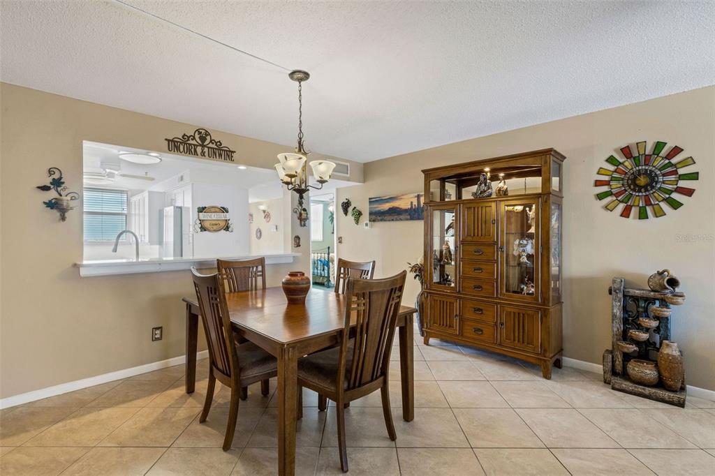 14900 Gulf Boulevard, Unit 410 Madeira Beach, FL 33708 - Photo 30 of 76 a view of a dining room with furniture and chandelier