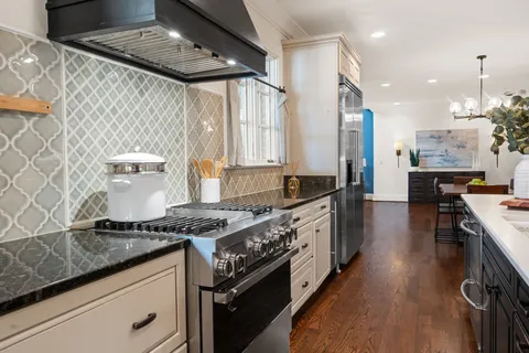 a dining room with wooden floor a chandelier a wooden table and chairs