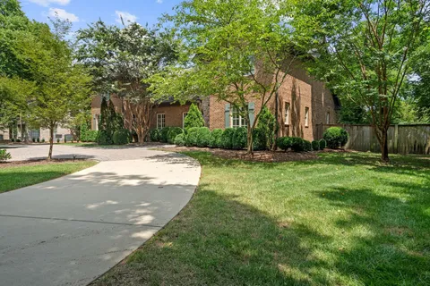 a backyard of a house with lots of green space and fountain