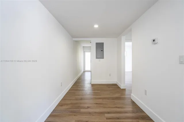 a view of a hallway with wooden floor