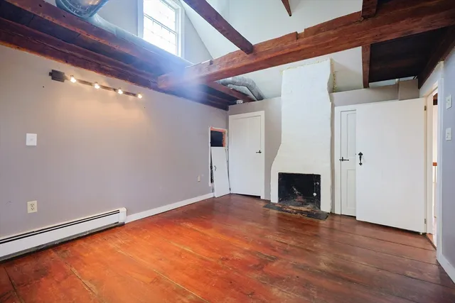 a view of an empty room with a fireplace and a window
