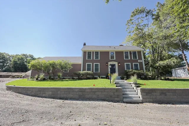 a front view of a house with a yard and trees