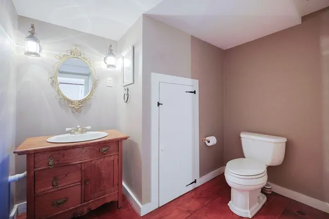 a bathroom with a toilet a sink and mirror