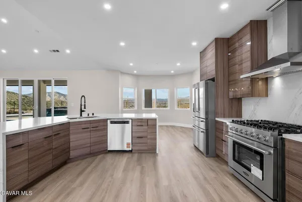 a kitchen with stainless steel appliances granite countertop wooden cabinets and a stove top oven