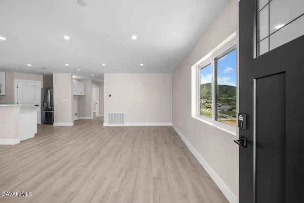 a view of a room with wooden floor and window