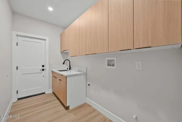 a view of a sink and cabinets with wooden floor
